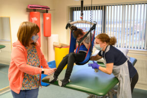 Therapy session with person using ceiling track hoist