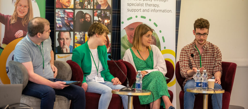 Four people sit together during a panel session at Cerebral Palsy Scotland conference 2022. There are two men and two women. All have cerebral palsy.