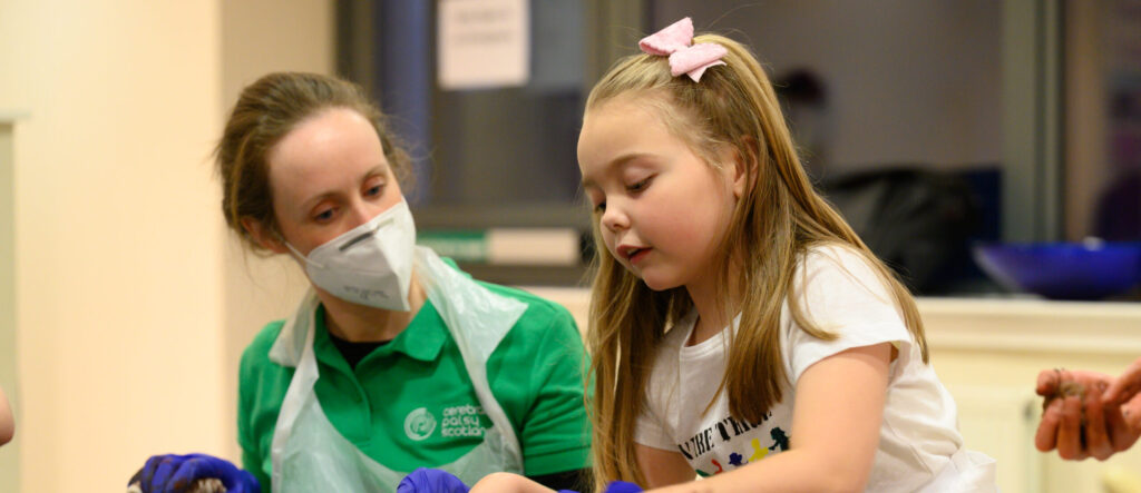 A Cerebral Palsy Scotland therapist works with a young girl at a therapy group.