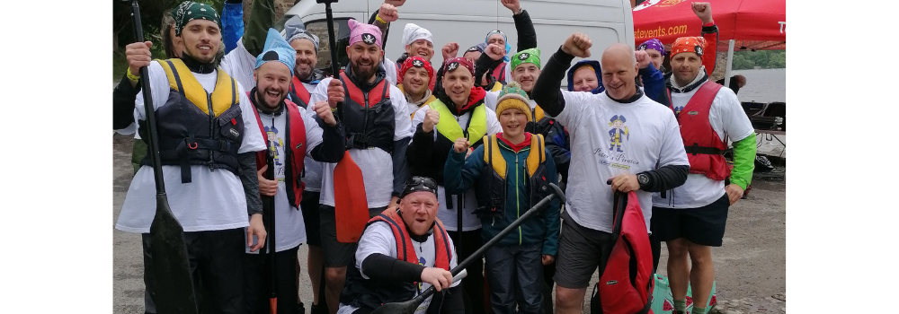 Allied Vehicles staff cheer in a group. They have just finished a Dragon Boat rowing race.