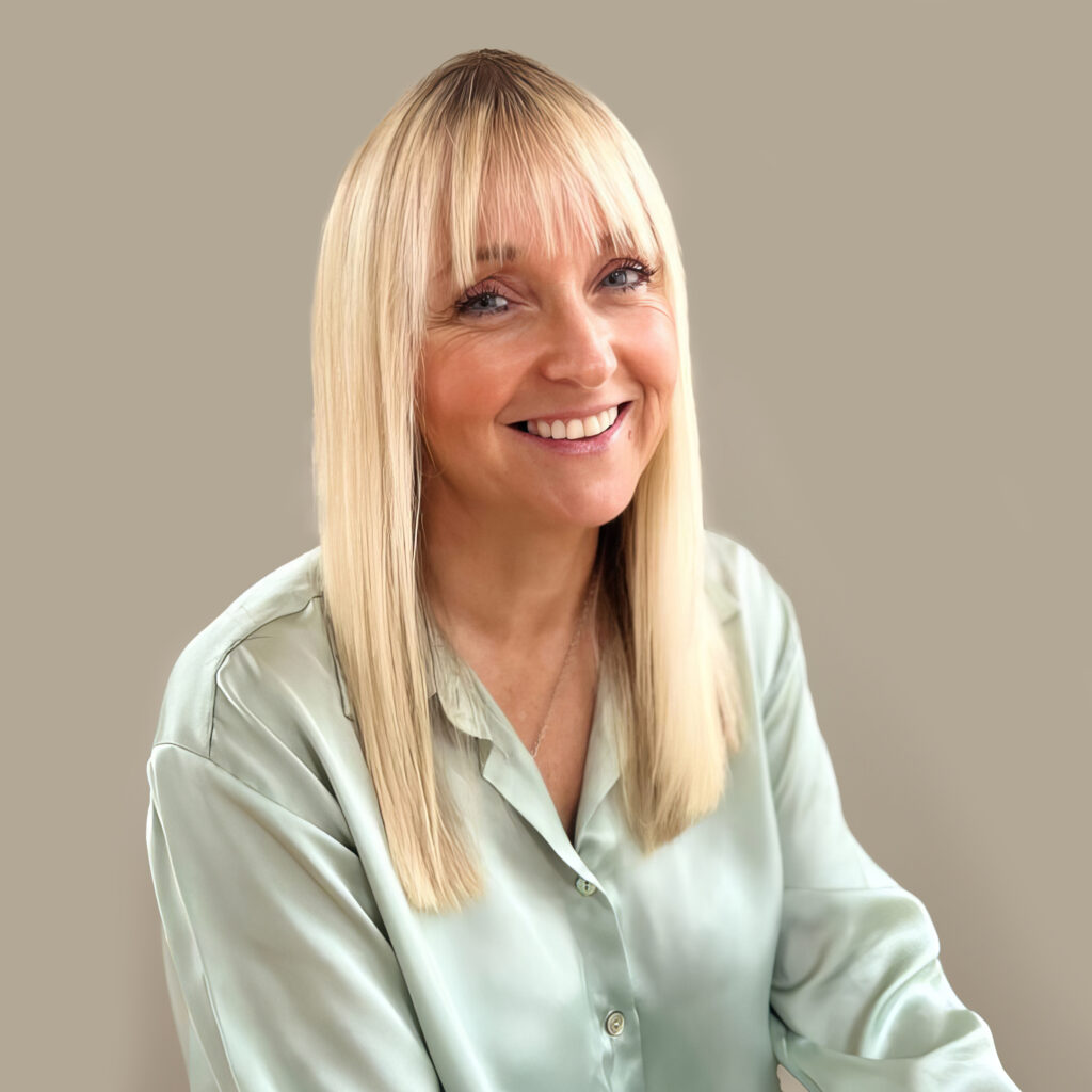 Woman with long blonde hair in a green blouse.