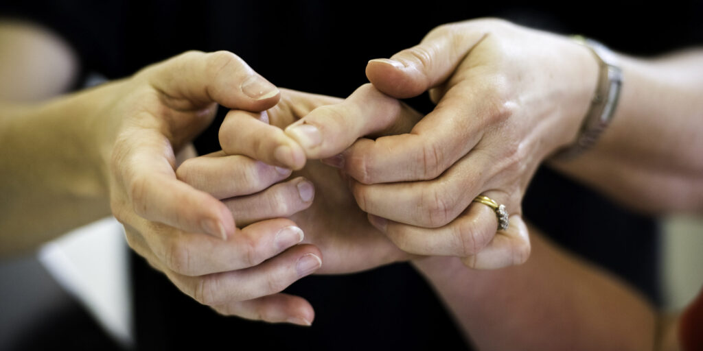A photo of a person holding another person's hand.